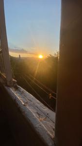 a view of the sunset from an open window at Дом Тины in Tbilisi City