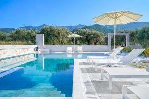 萨索斯Olia Thassos - Luxury Apartments的一个带白色椅子和遮阳伞的游泳池 更多37张照片