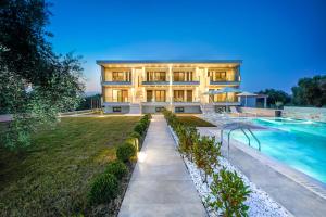 una casa grande con piscina frente a ella en Olia Thassos - Luxury Apartments, en Limenas