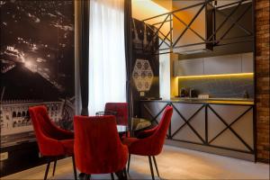 a dining room with red chairs and a table at Lofty Exclusive Apartments in Sarajevo