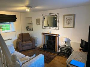 a living room with a fireplace and a chair and a mirror at Cottage with amazing views of the North York Moors in York