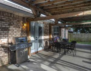 a patio with a grill and a table and chairs at Pool House, Short Drive to Beach, Grill, Smart TV in Navarre