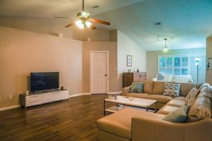 a living room with a couch and a flat screen tv at Pool House, Short Drive to Beach, Grill, Smart TV in Navarre
