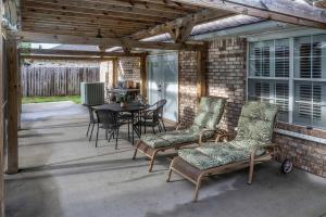 a screened porch with chairs and a table and a tableablish at Pool House, Short Drive to Beach, Grill, Smart TV in Navarre