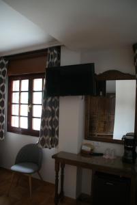 a kitchen with a table and a chair and a window at El ParaÍso de Guriezo in Pomar