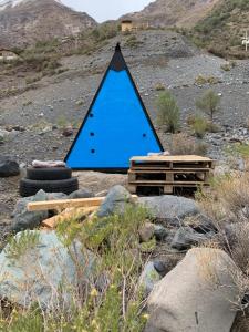 Una pirámide azul sentada sobre algunas rocas. en Glamping Roots del Yeso, en Los Chacayes