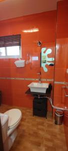 a bathroom with a white toilet and a sink at Apartamento rural in Alcántara