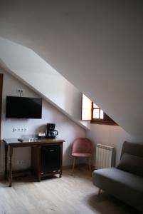 a living room with a couch and a table with a television at El ParaÍso de Guriezo in Pomar