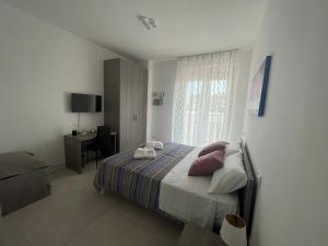 Schlafzimmer mit einem Bett, einem Schreibtisch und einem Fenster in der Unterkunft Bed & Breakfast Torre Mare in Salerno