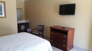 a bedroom with a bed and a dresser and a television at Murphy Motel in Letitia +15 photos