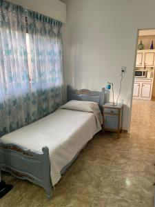a bedroom with a bed with a curtain and a table at CASA DEL NARANJO in Rosario
