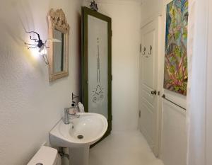 Baño blanco con lavabo y espejo en Araçatı Pansiyon, en Cesme