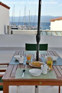 a wooden table with food on top of a balcony at Hydra Port Apartments in Hydra