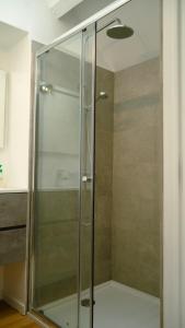 W łazience znajduje się prysznic ze szklanymi drzwiami. w obiekcie Les 3 Bilobas w mieście Héron