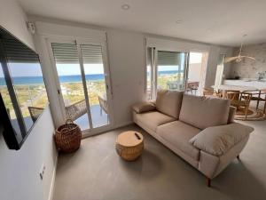 un soggiorno con divano e vista sull'oceano di Beautiful penthouse with pool and wonderful beach view a Oliva