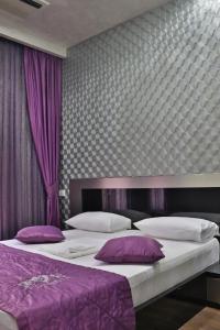 a bedroom with two beds with purple pillows at Hotel Roma & Tours in Yerevan