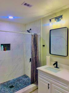 een badkamer met een douche en een wastafel bij STOP Inn STAY HOSTEL in Houston
