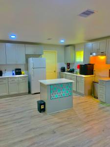 a large kitchen with white cabinets and a counter at STOP Inn STAY HOSTEL in Houston