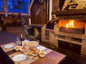 a table with plates of food and a fireplace at Guest House Lileya in Bukovel