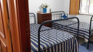 a bedroom with a bed with a blue and white comforter at 2-Beds Sleeps 4 10 min drive to Central Coimbra in Assafarge