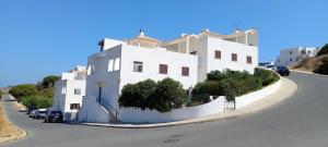 a white building with cars parked in front of it at Feliz Algarve in Albufeira