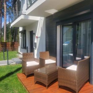 a group of chairs sitting on a patio at Haus am Meer Dziwnówek in Dziwnówek