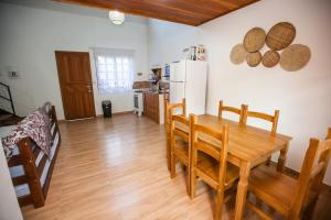 eine Küche und ein Esszimmer mit einem Holztisch und Stühlen in der Unterkunft RECANTO NOVÍSSIMO em BC na Praia do Estaleiro in Balneário Camboriú