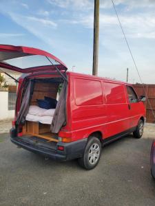 a red van with its door open with its back open at VW Campervan in Pembrokeshire