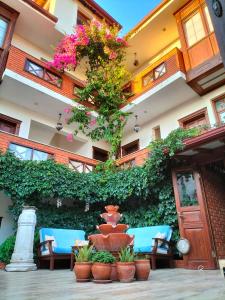 a building with plants and a fountain in a courtyard at Hotel Mary's House in Selçuk