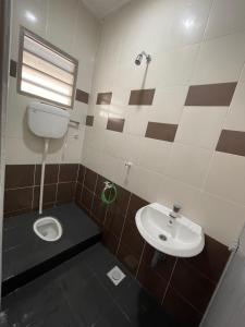 La salle de bains est pourvue de toilettes et d'un lavabo. dans l'établissement TAG Homestay Classic IPOH, à Lahat