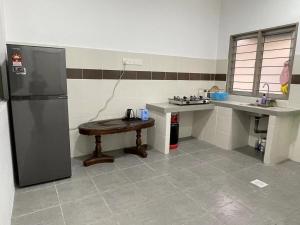 uma cozinha com um frigorífico e uma mesa em TAG Homestay Classic IPOH em Lahat