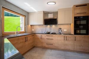 a kitchen with wooden cabinets and a large window at Chalet Fisti in La Villa