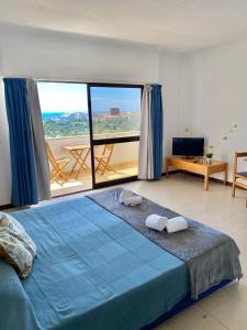 1 dormitorio con cama azul y ventana grande en Endless Summer, en Albufeira