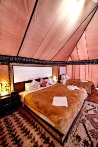a bedroom with a large bed in a tent at Fabulous luxury camp in Merzouga