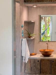 Un baño con lavabo de madera y espejo. en Casa Zulu - Vila Umoya, en Icaraí