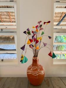 a brown vase with colorful flowers in a room at Casa Zulu Umoya in Icaraí