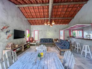 Una sala de estar con una mesa y sillas de madera. en Casa Zulu - Vila Umoya, en Icaraí