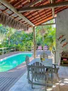 Casa Zulu Umoya في إيكاري: فناء مع طاولة وكراسي بجوار حمام سباحة