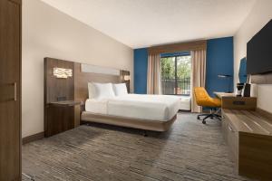 een hotelkamer met een bed, een bureau en een raam bij Holiday Inn Express & Suites Greenville-Downtown, an IHG Hotel in Greenville