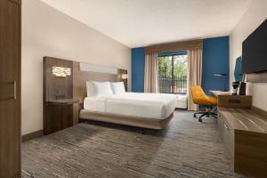 a hotel room with a bed and a desk and a window at Holiday Inn Express & Suites Greenville-Downtown, an IHG Hotel in Greenville