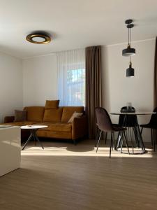 a living room with a couch and a table at Bell Tower Apartment in Plungė +8 photos