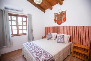 um quarto com uma cama e uma janela em Natureza e conforto - Estaleiro Balneário Camboriú no Balneário Camboriú