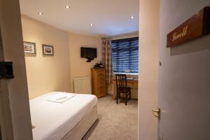 Schlafzimmer mit einem Bett, einem Schreibtisch und einem Fenster in der Unterkunft Caravelli in Loughborough