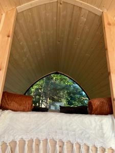 a bed in a room with a large window at Prie Balto ežero plius in Zarasai