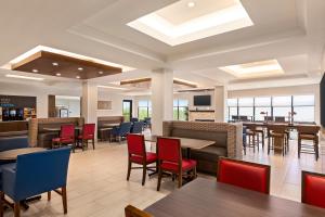 Holiday Inn Express & Suites Denver Airport, an IHG Hotel في دنفر: غرفة طعام مع طاولات وكراسي وكافتريا