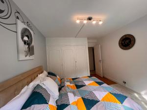 um quarto com uma cama com uma colcha colorida em Appartement Paris Grenelle - HALA PARIS em Paris