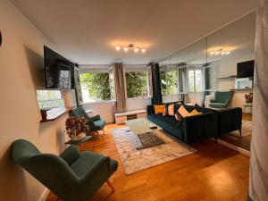 uma sala de estar com um sofá, cadeiras e janelas em Appartement Paris Grenelle - HALA PARIS em Paris