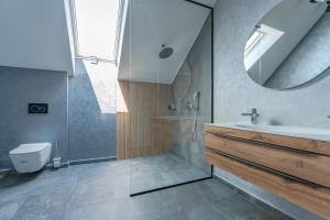 a bathroom with a shower and a sink and a mirror at premium suites Postavarului in Braşov +73 photos