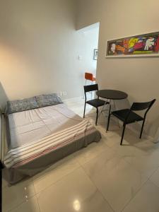 Lindo apartamento em Copacabana في ريو دي جانيرو: غرفة نوم بسرير وطاولة وكراسي