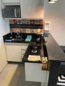 a kitchen with a counter with a stove and a sink at Lindo apartamento em Copacabana in Rio de Janeiro